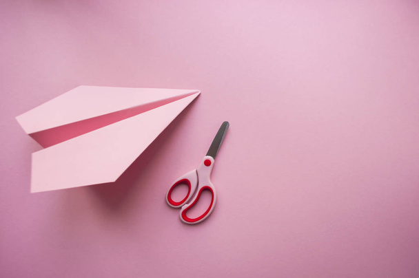 紙飛行機とピンクの背景のはさみ. - 写真・画像