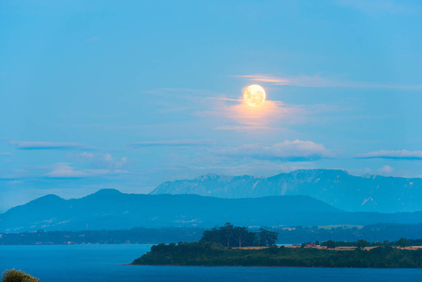 Luna che sorge tra le nuvole sul lago di Llanquihue, X Region de Los Lagos, Cile
 - Foto, immagini