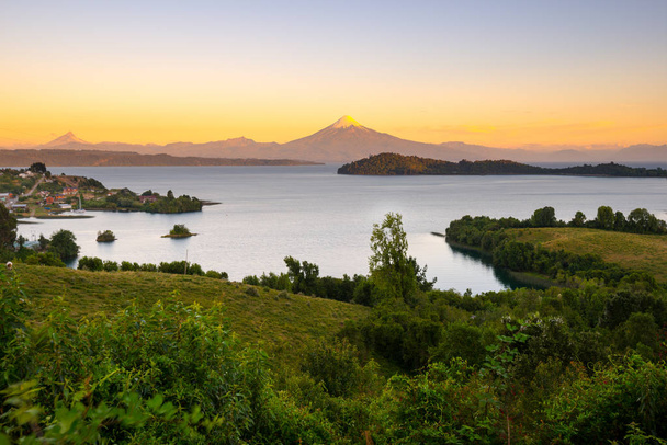 Vista de Puerto Octay a orillas del Lago Llanquihue, con Volcán Osorno y Volcán Puntiagudo en la parte posterior, X Region de Los Lagos, Chile
 - Foto, Imagen