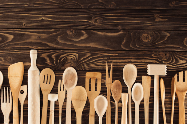 vista superior de los utensilios de cocina colocados en fila sobre una mesa de madera
 - Foto, Imagen