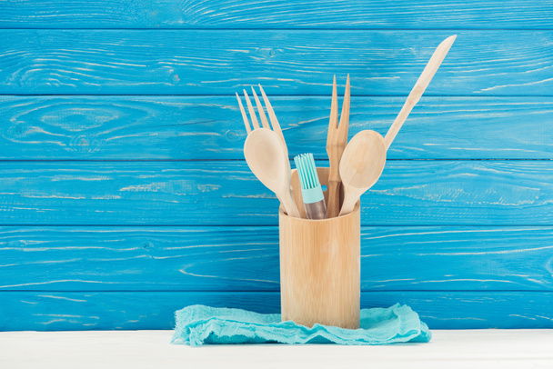 closeup view of rag, pastry brush and kitchen utensils in front of blue wooden wall - Photo, image