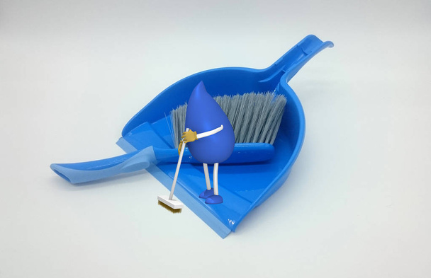Photo of a dustpan on which a 3d character of a drop-man  - Photo, Image