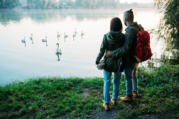 Walk a guy and a girl. Love story by the lake. Young people rest on nature. - Foto, afbeelding