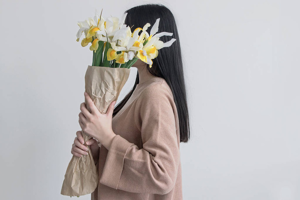 donna che tiene bouquet di fiori gialli iris
 - Foto, immagini