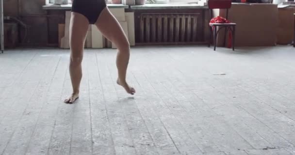 Young beautiful woman dancing in black swimsuit posing on a art studio background - Felvétel, videó