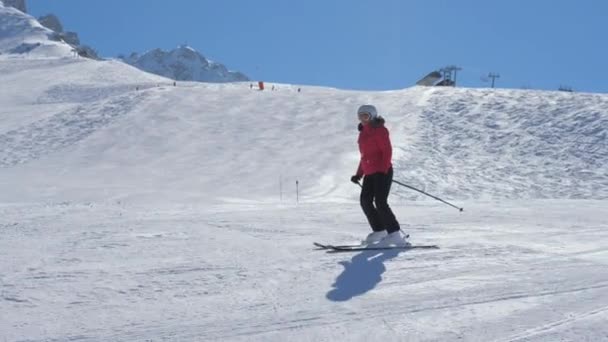 Kobieta narciarza wzdłuż stoku w górach w zimie - Materiał filmowy, wideo