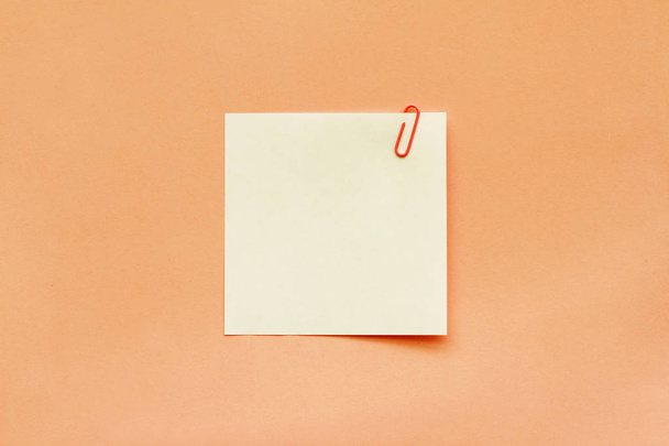White note paper label with clip on orange background - Valokuva, kuva