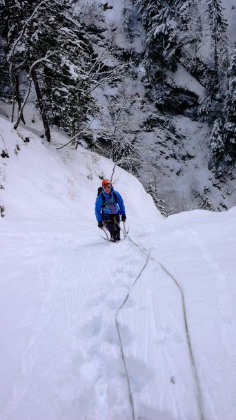 grimpeur de glace mâle sur une chute de glace gelée recouverte de neige fraîche épaisse dans l'étroite gorge de Tamina près de Bad Ragaz en Suisse
 - Photo, image