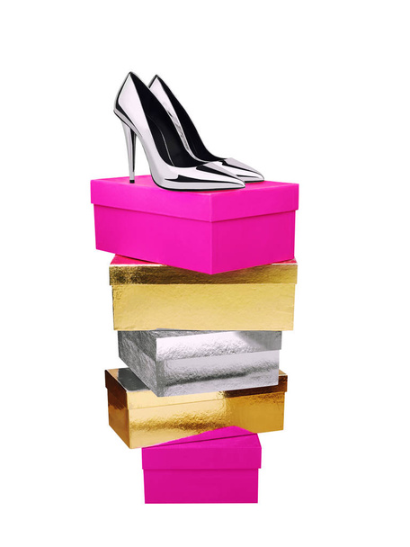 Zilveren schoenen van de vrouw op de top van gestapelde dozen geïsoleerd - Foto, afbeelding