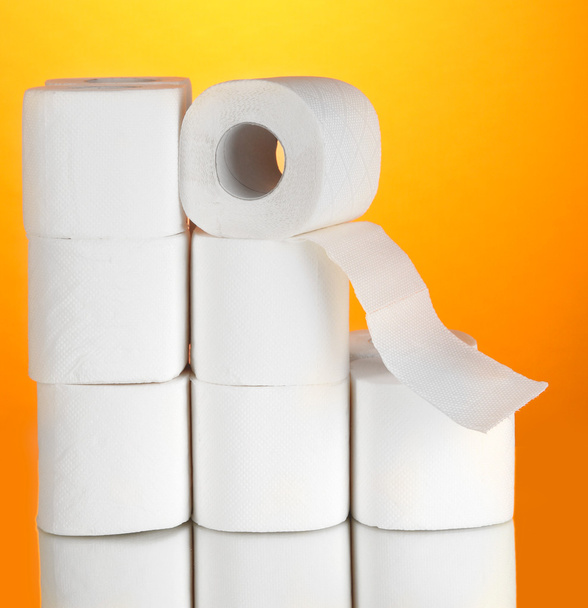 Rolls of toilet paper on orange background - Фото, изображение