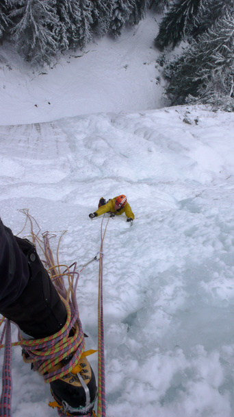 αρσενικό βουνό οδηγός αναρρίχηση απότομες παγωμένου καταρράκτη σε μια κρύα χειμωνιάτικη μέρα στις Άλπεις - Φωτογραφία, εικόνα