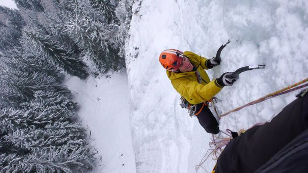 samec horského průvodce lezení strmých zmrazené vodopád na chladné zimní den v Alpách - Fotografie, Obrázek
