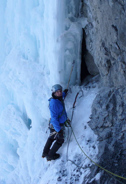 male ice climber on a steep icefall in the Swiss Alps near Davos - Photo, Image