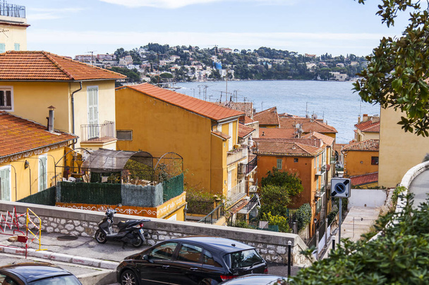 Villefranche-sur-Mer, FRANCE, on March 6, 2018. Picturesque urban view. The beautiful narrow street in the old city carries to the sea  - Foto, afbeelding