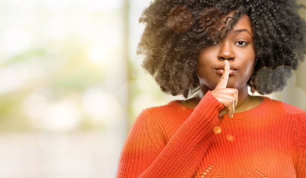 Красива африканська жінка з індексним пальцем на губах, просить бути тихою. Тиша і таємна концепція, на відкритому повітрі
 - Фото, зображення
