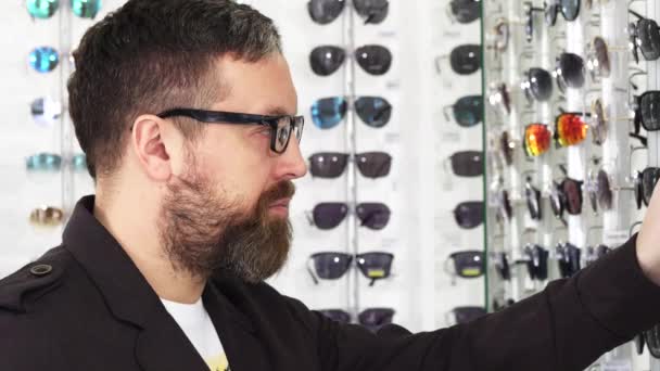 Detailní záběr Zralé muže zkoumání brýle na prodej na displeji - Záběry, video