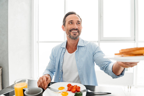 Happy mature man passing a plate - Photo, image