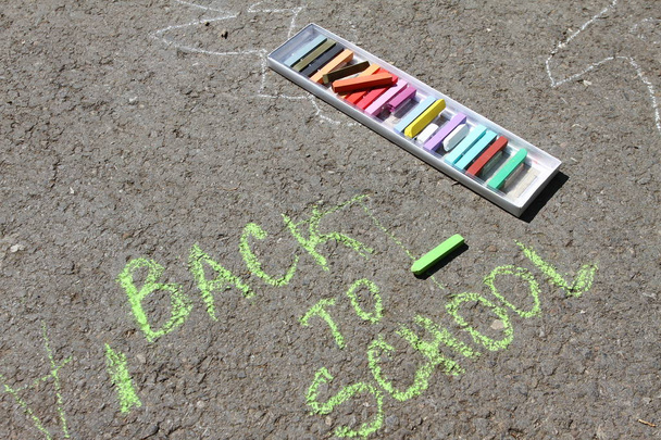 Torna a scuola sospiro scritto con gessetti colorati su un marciapiede. Ritornare a scuola su un asfalto. Concetto di scuola e vacanza. Concetto educativo. Scuola e divertimento. Non affilare
.  - Foto, immagini