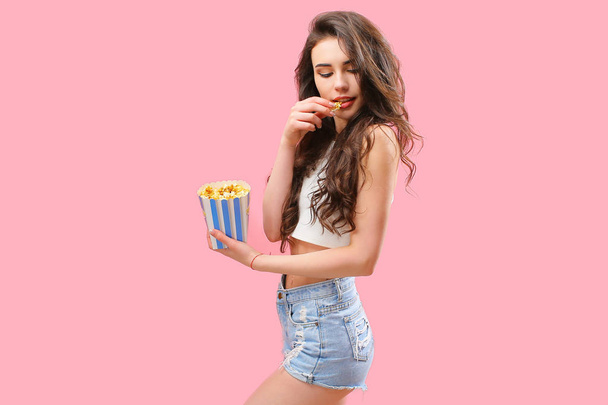 Playful girl with pack of popcorn - 写真・画像