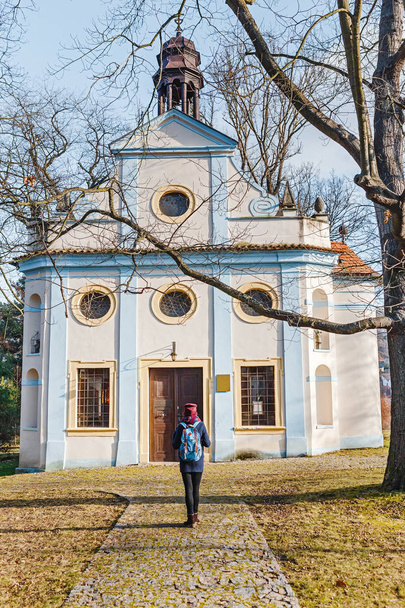 Religious tourist woman admires old St. Martin Chapel in Cesky Krumlov town - Photo, Image