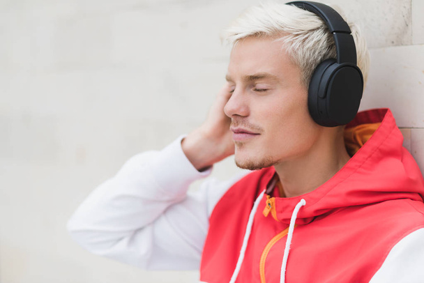 Side view of handsome male with blond hair dressed in red sports - Φωτογραφία, εικόνα