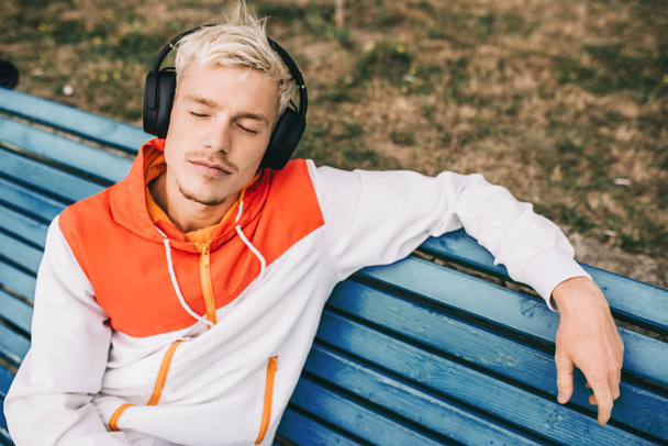 Above view of European young man enjoying and listening music on - Φωτογραφία, εικόνα