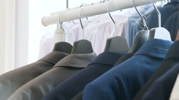 Gömlek, iş elbisesi ve T-shirt bir deposunda bulunan bir askı - Video, Çekim