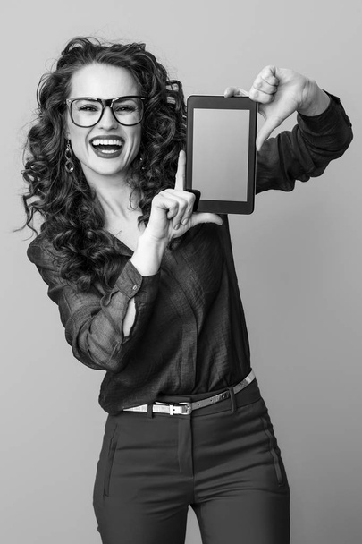 happy young woman with long wavy brunette hair showing tablet PC blank screen  - Fotoğraf, Görsel