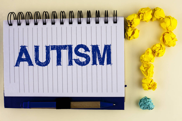 Wortschreibtext Autismus. Geschäftskonzept zur Sensibilisierung für Autismus, durchgeführt vom Sozialausschuss auf der ganzen Welt, geschrieben auf einem Notizbuch auf dem schlichten Hintergrund.. - Foto, Bild