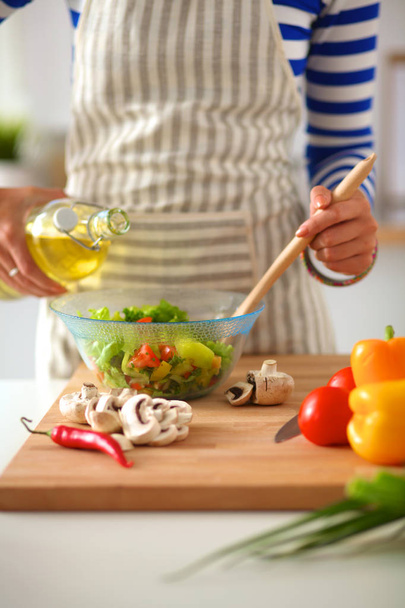 Young woman mixing fresh salad - Zdjęcie, obraz