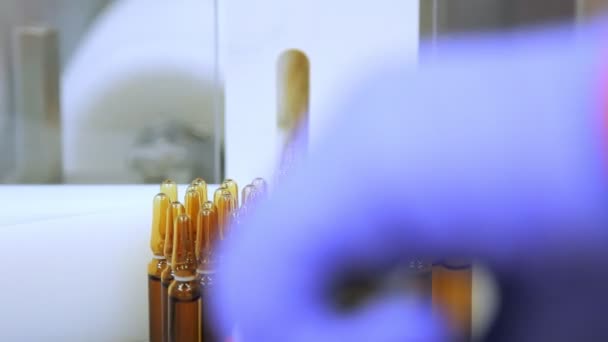 Medical vials on conveyor belt. Medicine ampoules manufacturing line - Felvétel, videó