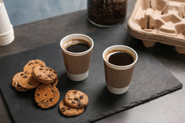 Composition with aromatic hot coffee in paper cups and cookies on table - Foto, imagen