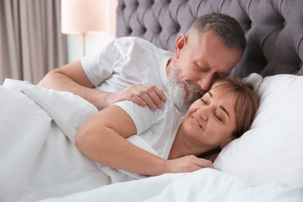 Mature couple together in bed at home - Фото, зображення