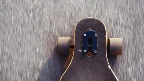 Top view handheld shot of man in blue sneakers or skaters shoes rides longboard on asphalt or city - Footage, Video