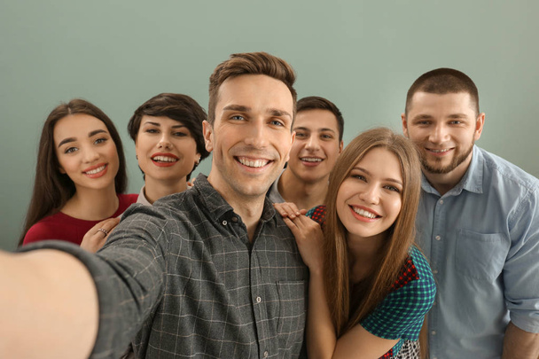 Happy friends taking selfie on color background - Photo, Image