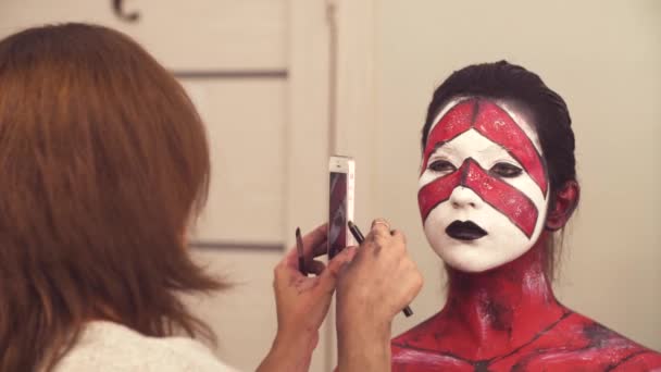 Make-up-Artist schießt ein Modell mit dem Smartphone - Filmmaterial, Video