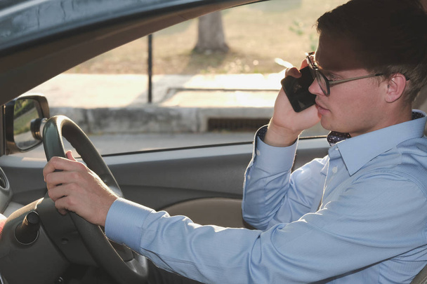 hombre de negocios conducir y hablar en el teléfono inteligente. caucásico hombre holdi
 - Foto, Imagen