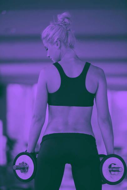 Gorgeous woman lifting some weights in gym - Фото, зображення