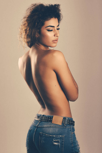 Young woman with beautiful back wearing blue jeans - Fotó, kép