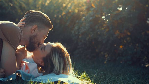 Junges Paar küsst sich auf dem Rasen - Foto, Bild