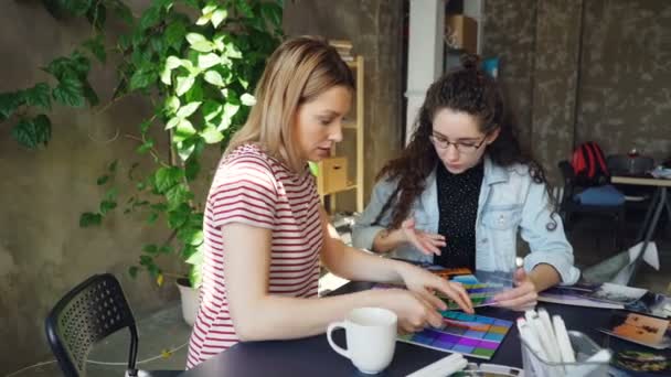 Female designers are working with color palettes to determine colors on photograph. They are celebrating success with high five. Work day in design company concept. - Footage, Video