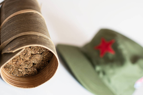 Cubaanse sigaren gerold in bananenblad en militaire cap op de backg - Foto, afbeelding