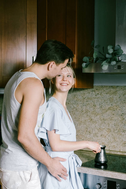Pretty woman and attractive man wearing stylish casual clothes making coffee at kitchen  - Valokuva, kuva