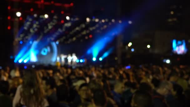 Tamplate azulado de silhuetas de multidão de concerto na frente de luzes de palco brilhantes. 120fps
 - Filmagem, Vídeo