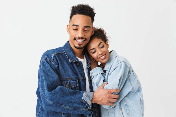 Happy lovely african couple in denim shirts hugging together - 写真・画像