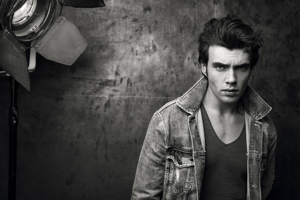 Stylish young man in a denim jacket. Conceptual black and white fashion portrait - Photo, Image