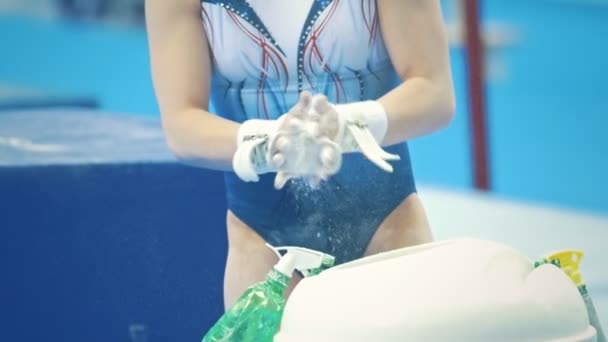 Χέρια αθλητική γυμναστής κατά παλαμάκια λευκή κιμωλία σε σκόνη στο πρωτάθλημα - Πλάνα, βίντεο
