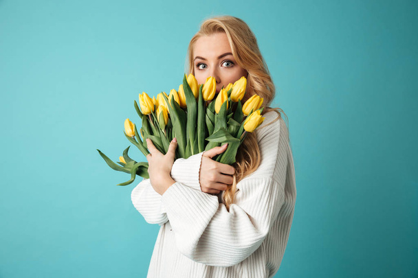 Portrait of a surprised young blonde woman in sweater - Foto, imagen