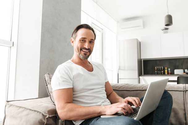 Smiling mature man using laptop computer - Fotoğraf, Görsel