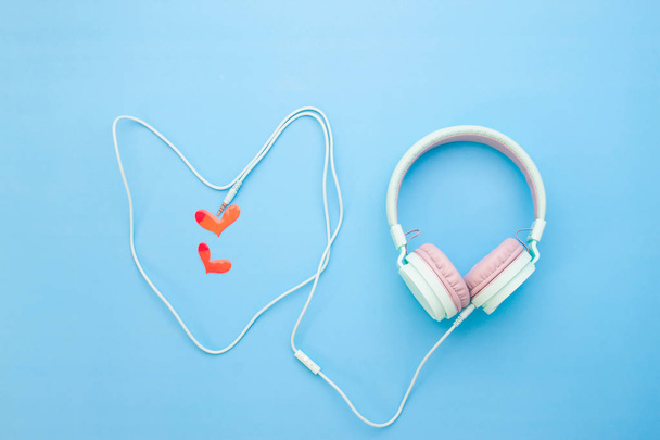 Pastel color headphone heart shape with little red heart on blue color background, Love emotion - Photo, Image
